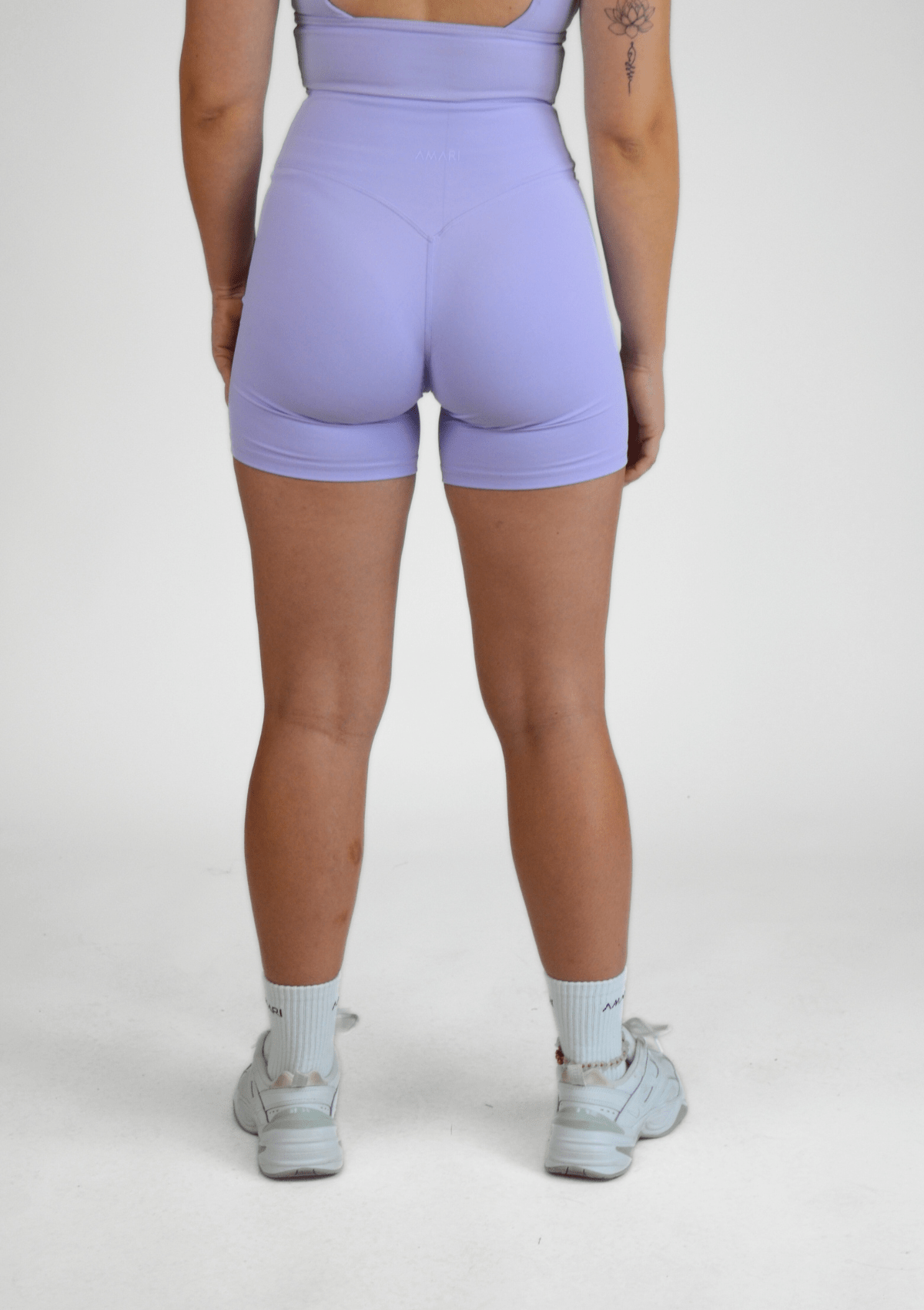 Person wearing light purple athletic shorts on a white background